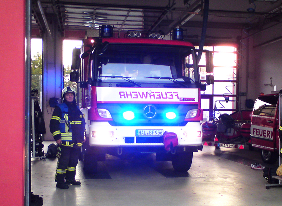 Steffen Neubert vor einem Löschfahrzeug der Feuerwehr Halle